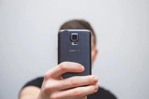A person holding up a smartphone to take a photo