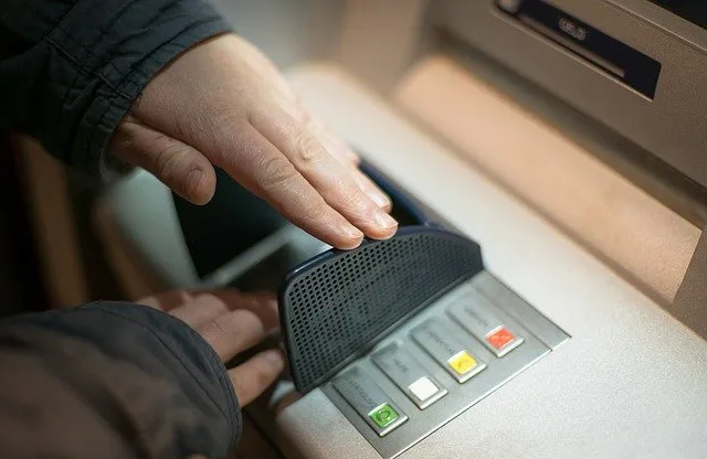 A hand shielding a keypad while entering a PIN