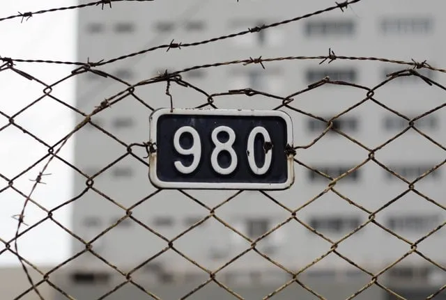 A number plate on a prison perimeter fence