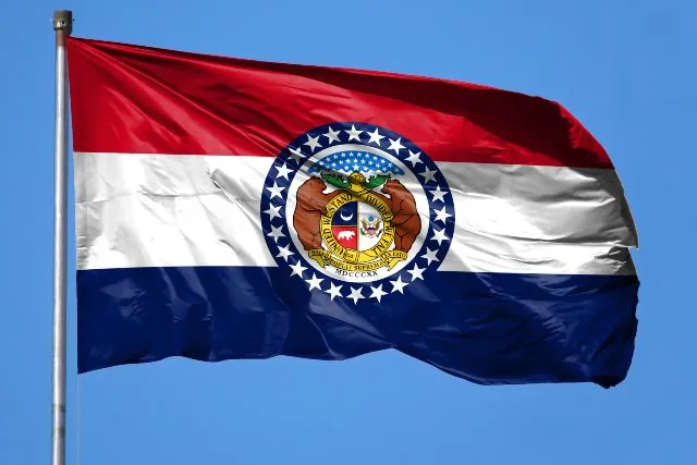 The Missouri state flag against a blue sky