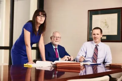Three attorneys at a conference table in a law office