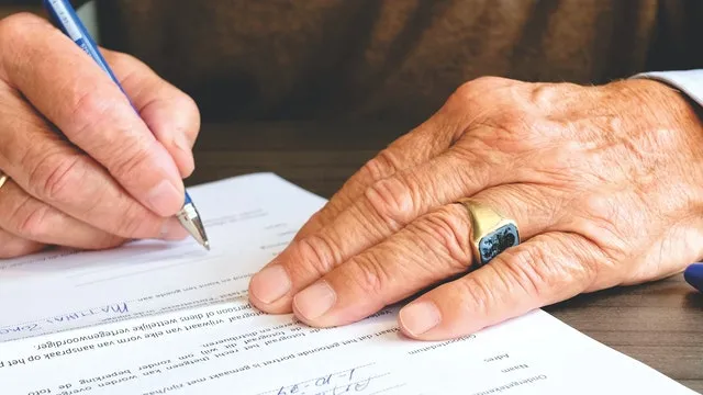A person signing a court form by hand