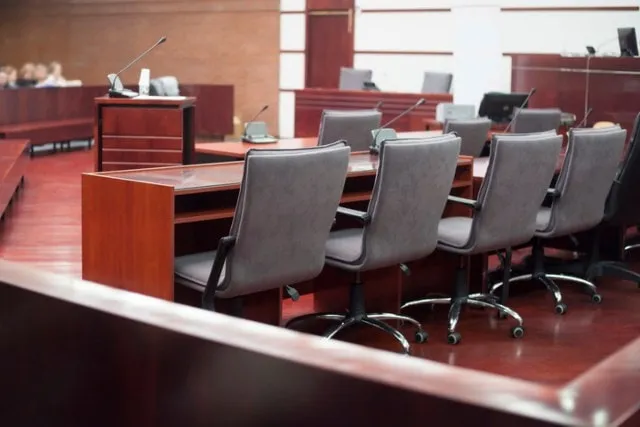 An empty courtroom with the bench and counsel tables