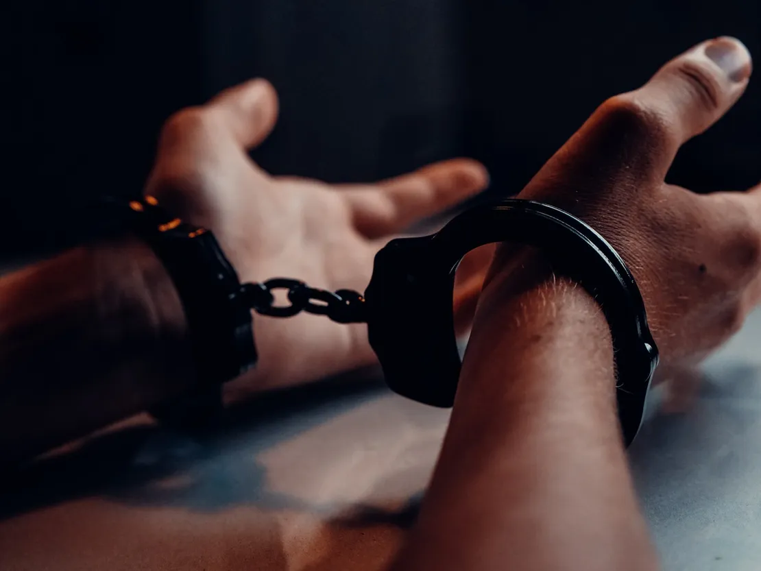 Handcuffs being fastened around a person's wrist