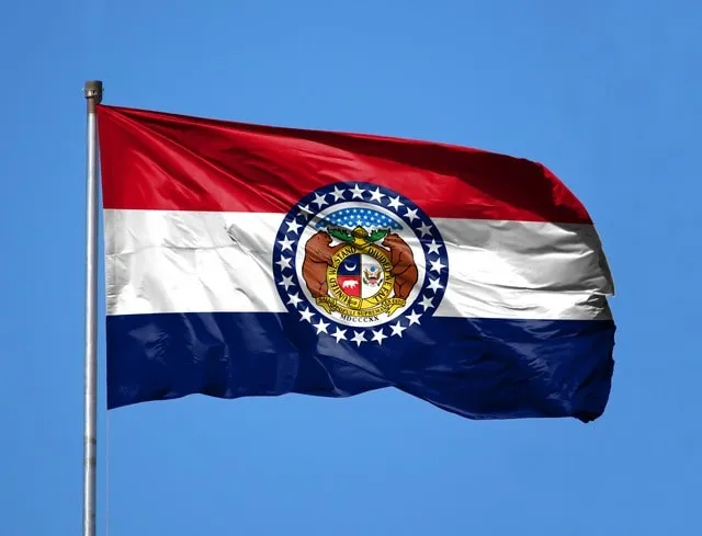 The Missouri state flag flying against a blue sky