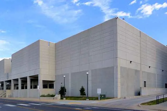 A large concrete records building beside an empty road