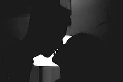 A silhouetted figure in near darkness