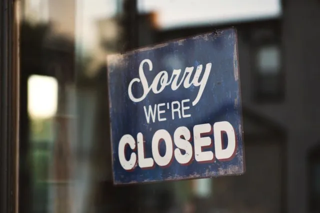 A Sorry We're Closed sign hanging in a shop window