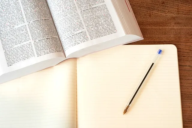 An open law book beside a blank notepad and pencil