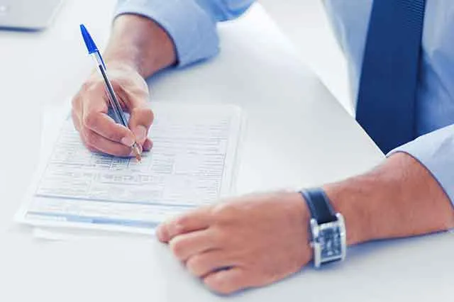 A person filling in a tax form by hand