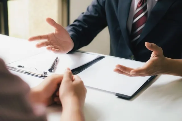 A lawyer talking with a client across a desk